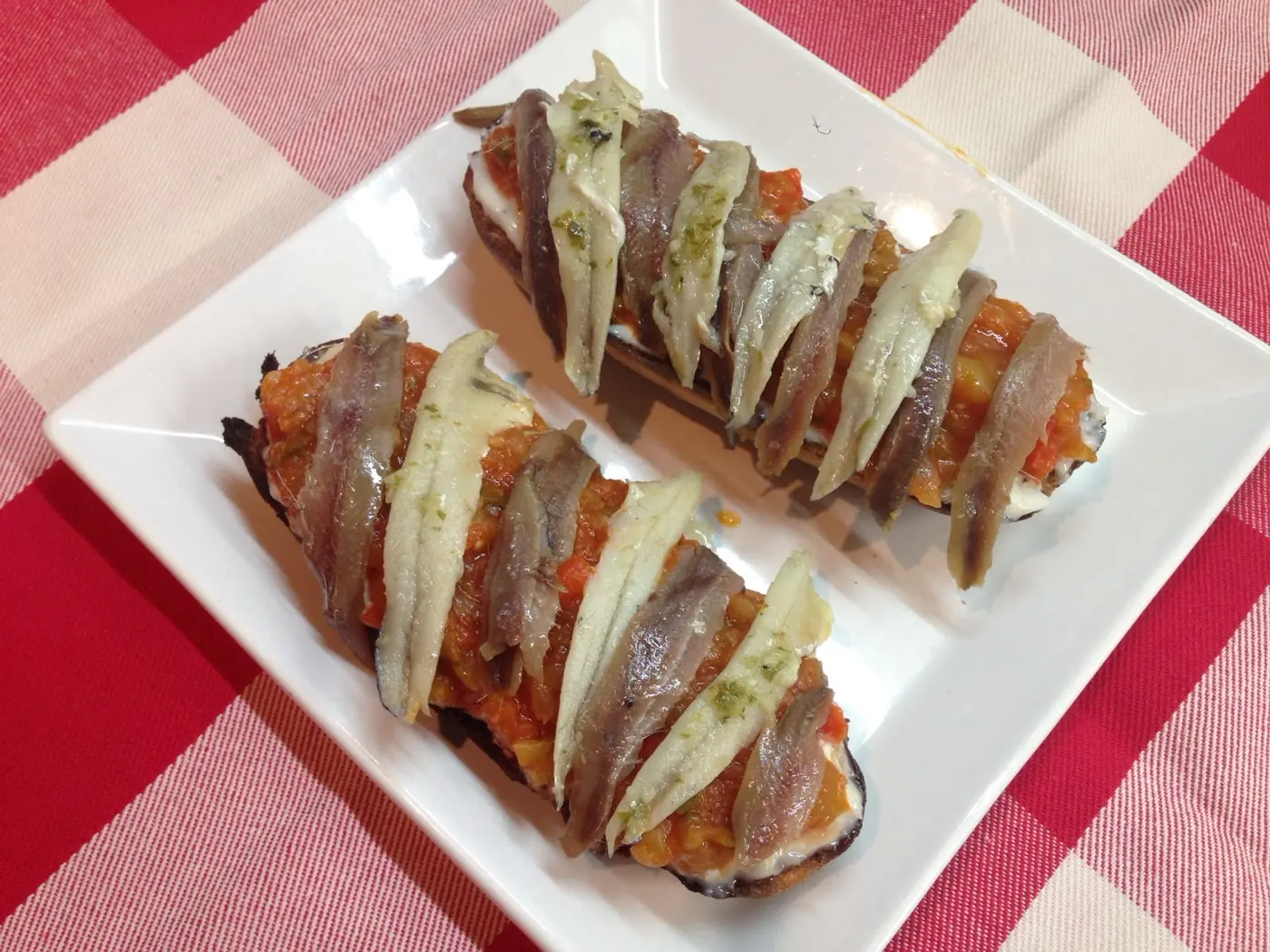 Mollete de anchoas con boquerones en cama de pisto y alioli